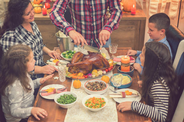 istock Young father carving roasted Thanksgiving turkey 1056864042