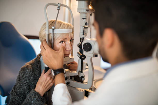 mulher tendo um exame no consultório do oftalmologista. - patient senior adult optometrist eye exam - fotografias e filmes do acervo