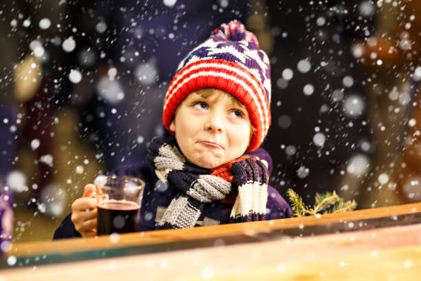 istock Little kid boy drinking hot chocolate on Christmas market 1056867284