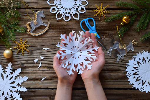 Making paper snowflakes with your own hands. Children's DIY. Merry Christmas and New Year concept