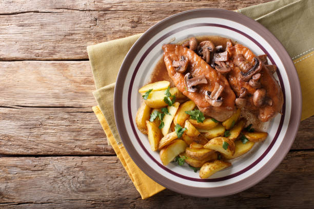 pollo in salsa marsala con funghi e patate fritte da vicino su un piatto. visualizzazione orizzontale superiore - trapani close up sicily italy foto e immagini stock