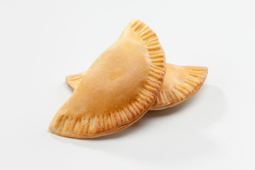 Empanadas on white background. Studio shot. An empanada is a type of pasty baked or fried in many countries of the Americas and in Spain. Empanadas are made by folding dough over a stuffing, which may consist of meat, cheese or other ingredients.