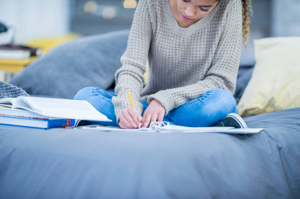 istock Studious teen girl doing homework 1056881628