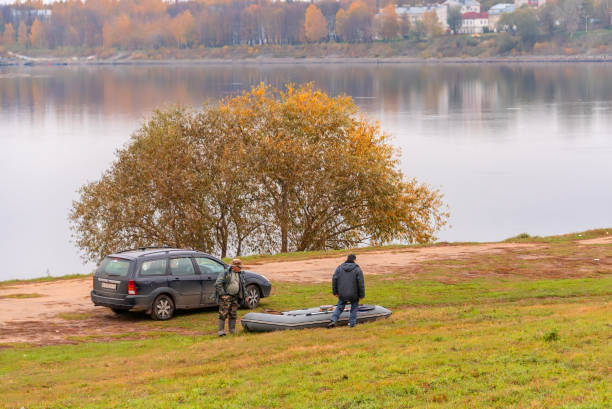 Uglich, Russia - October 13, 2018.Fishermen on the shore are preparing the boat for launching.