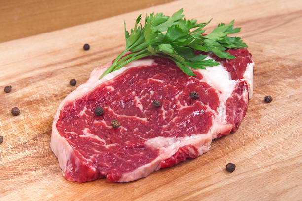 istock Fresh raw beef steak on wooden and white background. 1056903882
