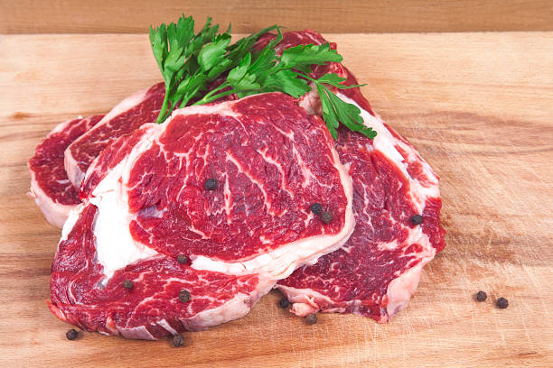 istock Fresh raw beef steak on wooden and white background. 1056905250