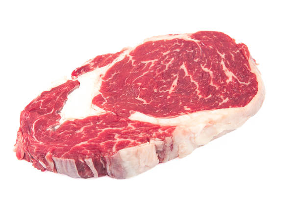 istock Fresh raw beef steak on wooden and white background. 1056906342