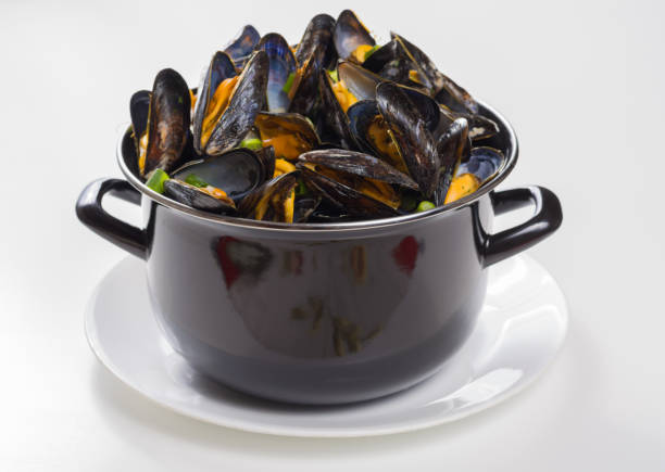 istock Black pan with cooked with green onion, parsley marinated high quality mussels 1056906474