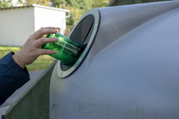 istock throwing a glass bottle to recycle container 1056909260