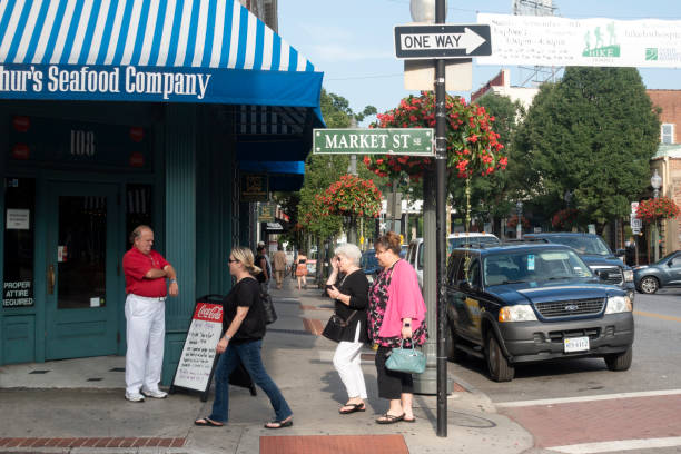 Roanoke, USA - August 10, 2018. Group of ladies walking on sidewalk along Market Street with a man standing at the entrance of a restaurant in downtown Roanoke, Virginia, USA
