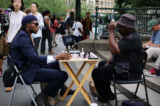 Close-up of a senior man playing chess in a city square