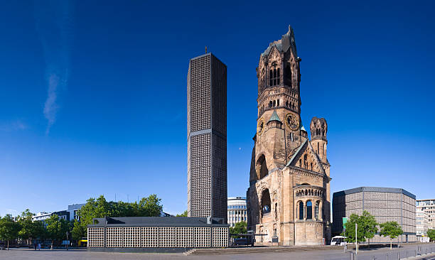 Panorama of the Kaiser Wilhelm Memorial Church and grounds One of Berlin's most famous landmarks, the Kaiser-Wilhelm-Gedächtnis-Kirche between the Europa-Center and Kurfürstendamm, the broken spire and modern bell tower overlook the busy Breitscheidplatz as symbols of the city's regeneration. Perspective corrected stitched panorama detail when viewed large. kaiser wilhelm memorial church stock pictures, royalty-free photos & images