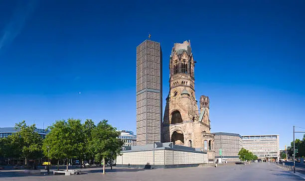 One of Berlin's most famous landmarks, the Kaiser-Wilhelm-Gedächtnis-Kirche between the Europa-Center and Kurfürstendamm, the broken spire and modern bell tower overlook the busy Breitscheidplatz as symbols of the city's regeneration. Perspective corrected stitched panorama detailed when viewed large.