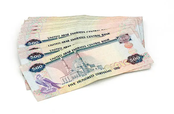 A pile of Five Hundred Dirham notes on white background.