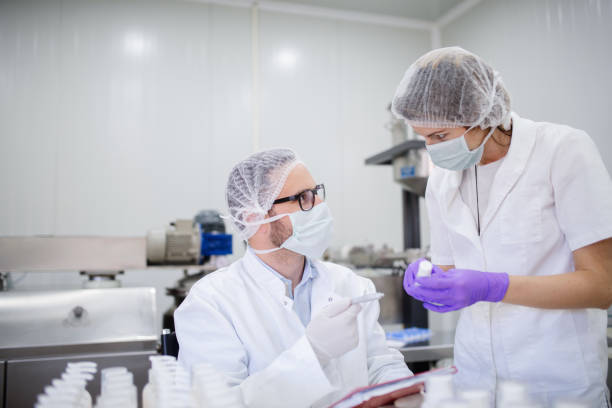 istock Technologist holding test results and his assistant holding cosmetic product. 1056915818