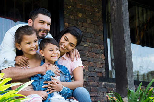 Familia sentada fuera de su casa photo