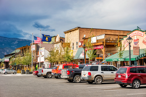 Cars are parked in front of businesses at the north entrance to Yellowstone Park in the town of Gardiner, Montana, USA on an overcast day.