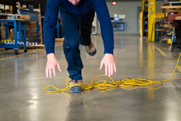 um trabalhador que tropeçar em um fio elétrico em ambiente industrial - extension cord - fotografias e filmes do acervo