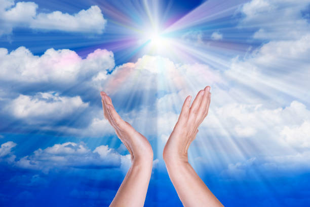 istock Healing hands in the sky with bright sunburst 1056923888