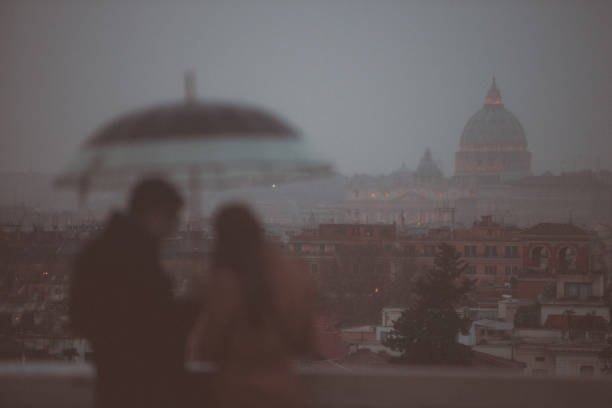 istock Rainy day in Rome: tourists with umbrellas 1056923944