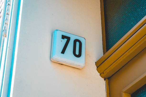 istock number 70 door sign with yellow wall 1056924164