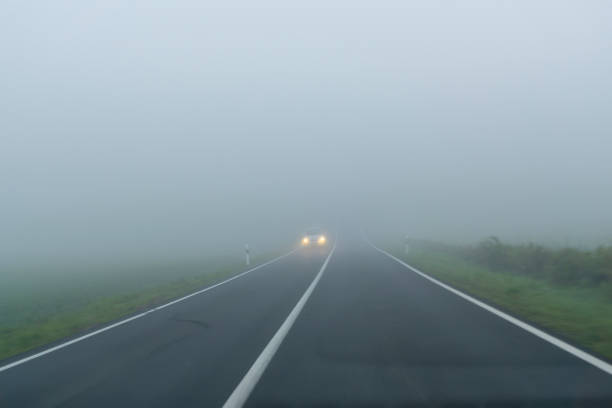 霧の中で秋の朝の道 - fog road autumn highway ストックフォトと画像