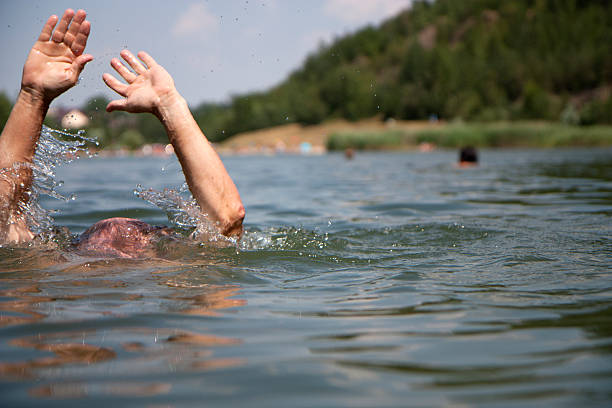 istock Swimmer with hands up drowning in lake 105692504