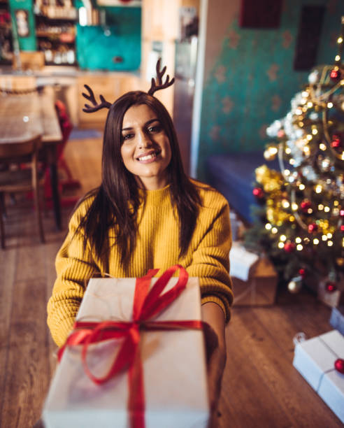 istock woman giving the christmas present 1056925642