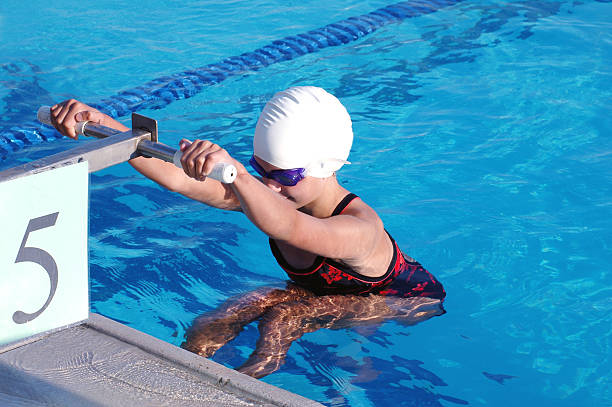 młody dziewczyna pływak rozpoczęciem styl grzbietowy w kąpieli spełniają - athlete sport starting line muscular build zdjęcia i obrazy z banku zdjęć