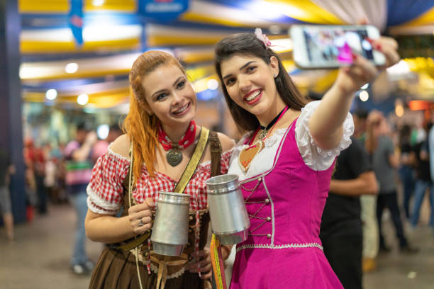 chicas amigos tomando un selfie en brindis celebración en oktoberfest - europeo del norte fotografías e imágenes de stock