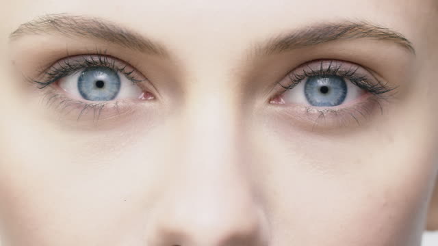 Young woman opening and closing her blue eyes