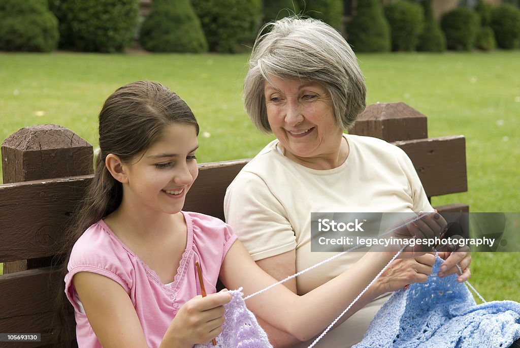 祖母と孫娘とともに会話を Crocheting - 教えるのロイヤリティフリーストックフォト