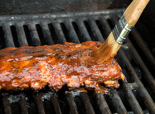 Costillas de cerdo asado con salsa de barbacoa cepillo de aplicar - foto de stock