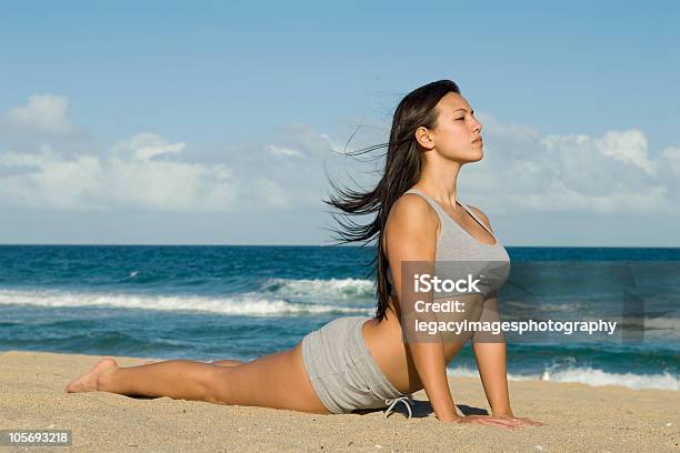 Young Woman Practicing Yoga Cobra Pose On The Beach Stock Photo - Download Image Now