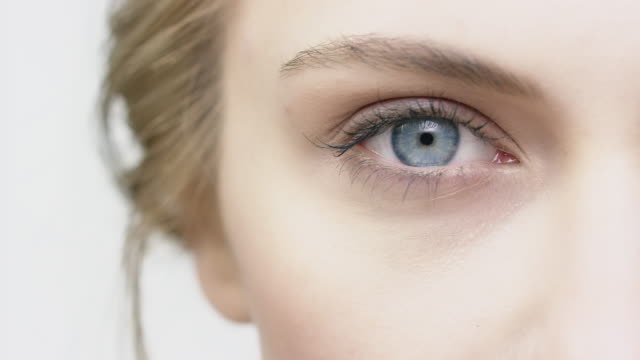 Cropped image of woman opening her blue eye