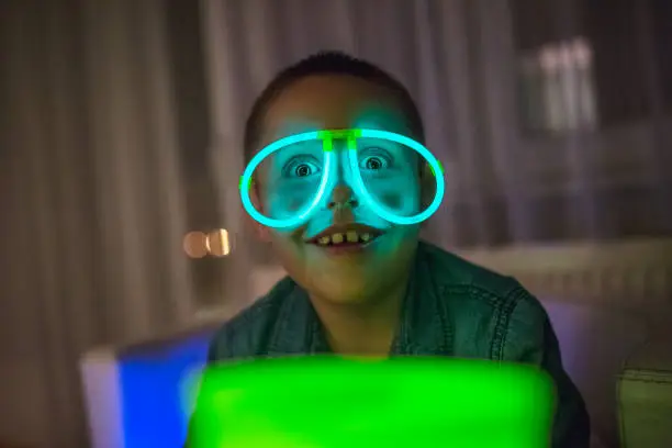 Boy wearing neon eyeglasses and having fun