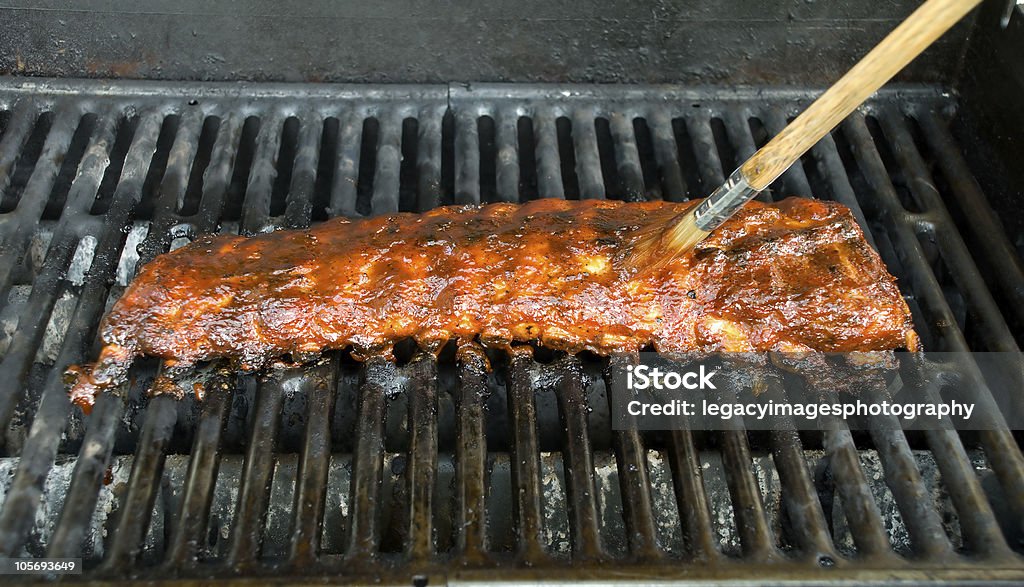 Barbecue Baby Back Ribs with Brush Applying BBQ Sauce Brush slathering on BBQ Sauce on a rack of baby back ribs Rib - Food Stock Photo Barbecue Baby Back Ribs with Brush Applying BBQ Sauce Brush slathering on BBQ Sauce on a rack of baby back ribs Rib - Food Stock Photo