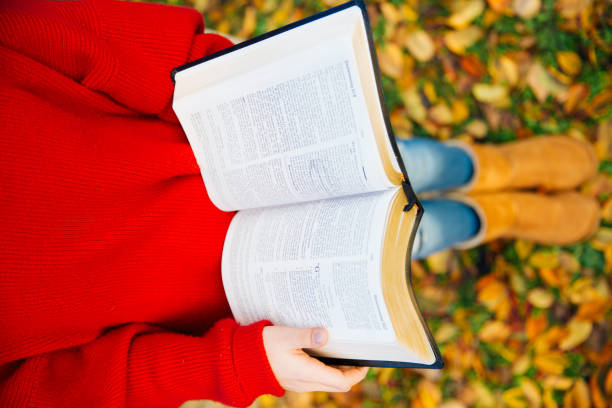 istock Girl reading a Holy book in the park 1056937754