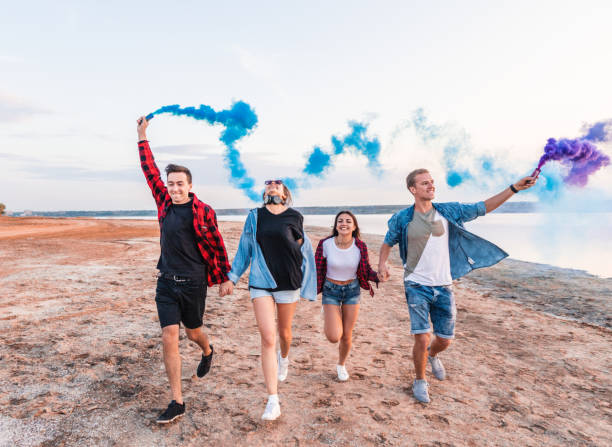 istock young friends running with hand flare or fusee 1056937760