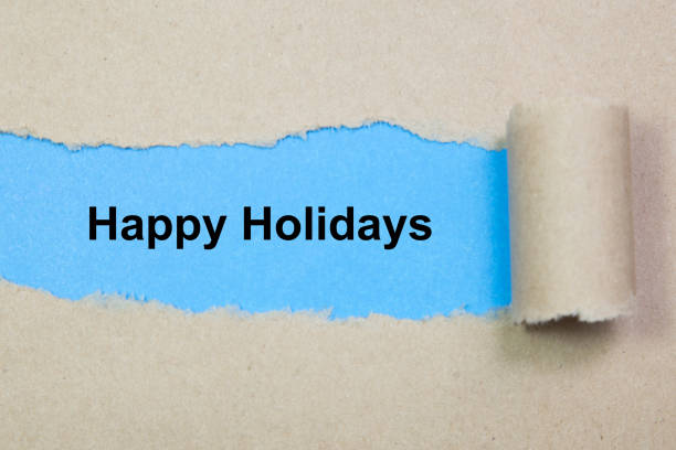 istock happy holidays text on paper. Word happy holidays on torn paper. Concept Image. 1056945402
