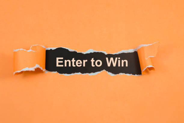 istock Enter to win text on paper. Word Enter to win on torn paper. Concept Image. 1056945464
