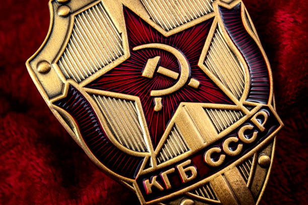 Secret service, intelligence agency, and espionage concept with macro close up on a cold war era KGB badge from the former USSR on red background Secret service, intelligence agency, and espionage concept with macro close up on a cold war era KGB badge from the former USSR on red background russian military photos stock pictures, royalty-free photos & images