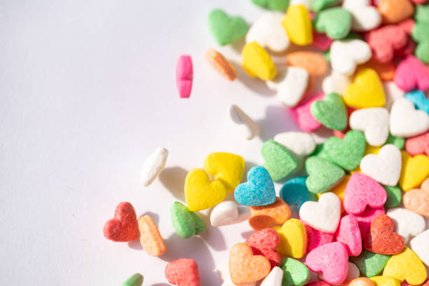 istock sugar small candy heart shape dancing on white background 1056964022