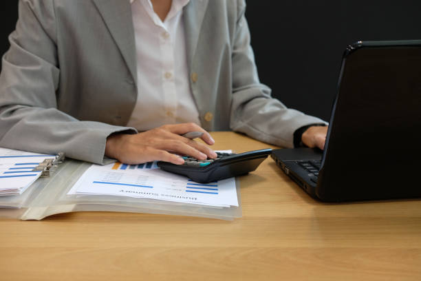 istock financial adviser working with calculator & computer. accountant doing accounting & calculating revenue & budget. bookkeeper making calculation. finance & economy concept 1056971560