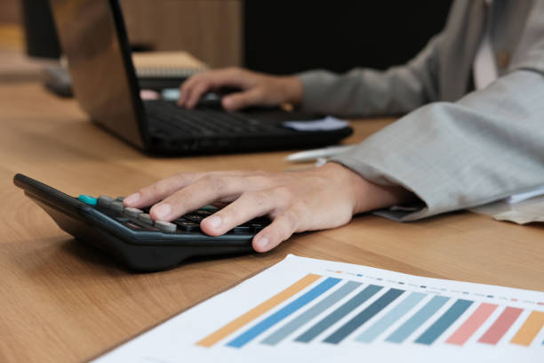 istock financial adviser working with calculator & computer. accountant doing accounting & calculating revenue & budget. finance & economy concept 1056971590