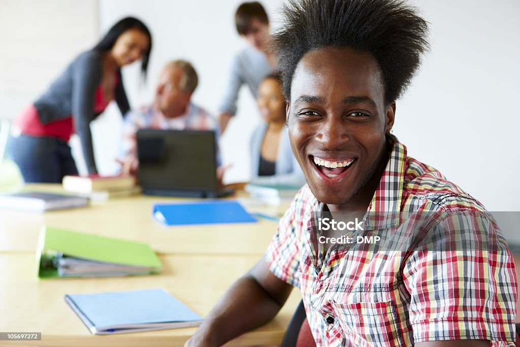 Zbliżenie z szczęśliwy Czarna student siedzi przy biurku w college'u - Zbiór zdjęć royalty-free (Biurko)