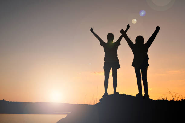 istock Silhouette People Standing On Mountain Against Sky During Sunset 1056974894