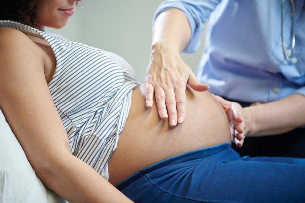 pregnancy check up a pregnant lady is examined by female doctor at the clinic Midwife stock pictures, royalty-free photos & images