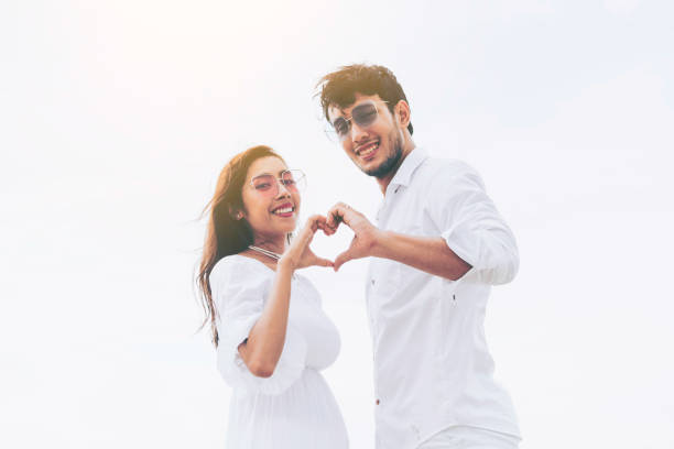istock Young couple shows heart shape hand gesture. 1056986578