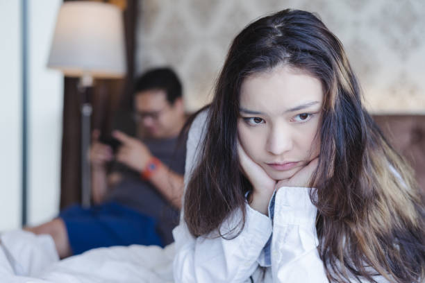 istock Pensive upset woman feeling offended, thinking over problems in relationships when her boyfriend playing game. Unhappy couple concept 1056990284